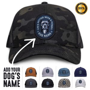 May include: Black and green camouflage trucker hat with a blue patch that says "Life's Better With A Pitbull Dog Name". The patch features a black and white pitbull dog head. The hat is available in a variety of colors and patterns.