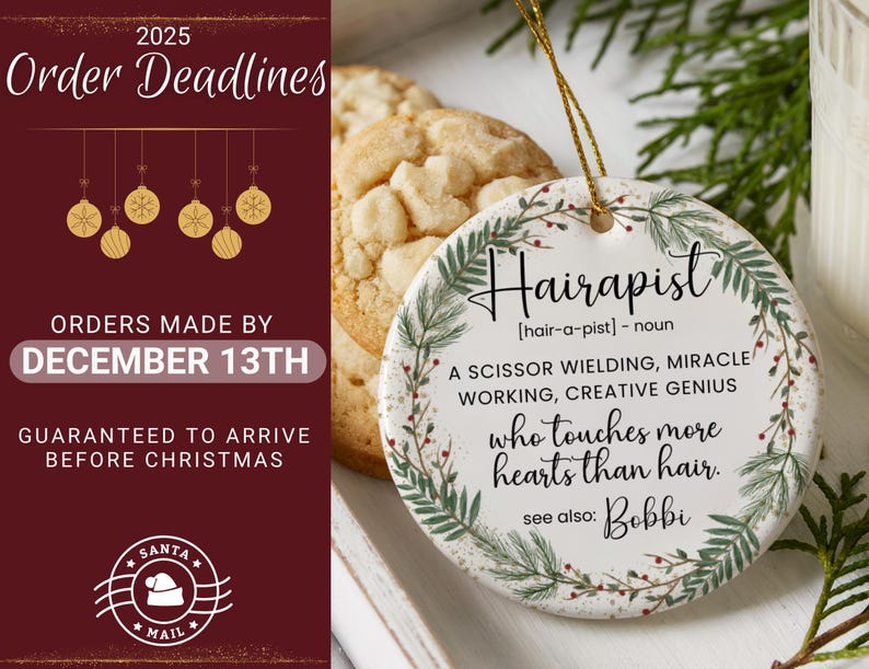 May include: A round, white ceramic ornament with the word "Hairapist" in black script, surrounded by a green and red leaf design. The ornament has text that reads "A scissor wielding, miracle working, creative genius who touches more hearts than hair."