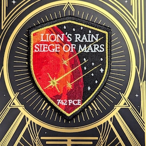 May include: A black, red, and gold patch with the text "LION'S RAIN SIEGE OF MARS" and "742 PCE". The patch features a red planet with three golden shooting stars against a black background.