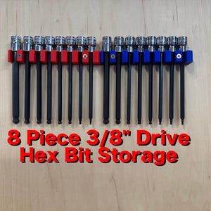 May include: An 8-piece hex bit set with 3/8" drive, displayed on a wooden surface. The bits are held in red and blue holders. The text "8 Piece 3/8" Drive Hex Bit Storage" is displayed in red.