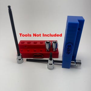 May include: A collection of tools, including a long black hex key, sockets, and a blue holder with "sae" text. A red holder with multiple holes and the text "mm" is also present. The text "Tools Not Included" is displayed in red.