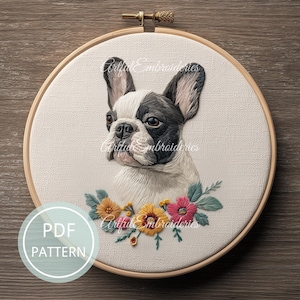 Op de afbeelding: Geborduurd kunstwerk van een Franse Bulldog in een houten hoepel. De hond is zwart en wit met een bloemenslinger van geel, roze en groen. De tekst "PDF PATTERN" staat in een cirkel linksonder.