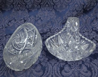 May include: Two clear glass bowls with intricate cut designs. One bowl is oval shaped and the other is a basket shape with a handle.