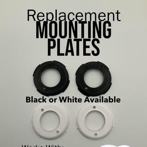 May include: Image shows replacement mounting plates for a Google Nest Battery camera. The image includes two black and two white circular plates, along with a white camera. Text on the image reads "Replacement MOUNTING PLATES" and "Black or White Available."