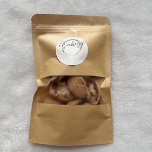 May include: A brown paper bag with a clear plastic window, containing a small amount of shelled walnuts. The bag has a white sticker with the text "Smokeys Small Pets" on it.