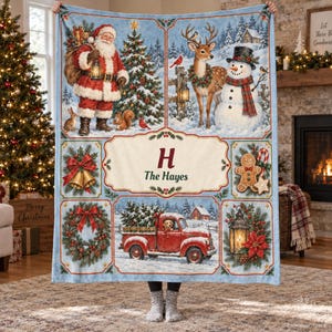 May include: A rectangular fleece blanket featuring a collage of Christmas scenes including Santa Claus, a deer, a snowman, a red truck, and a gingerbread man. The center panel displays the letter H and the text The Hayes in dark red.