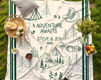May include: A white camping blanket with green accents and a nature-themed design. The blanket features illustrations of trees, mountains, hiking boots, and the text "ADVENTURE AWAITS STEVE & JEN 2025".