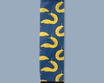 May include: A pair of socks with a navy blue background and a repeating pattern of yellow slugs. The socks have a black toe and heel. The slugs are stylized with a curved body and small antennae.