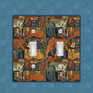 May include: A decorative double light switch cover featuring a repeating pattern of stylized cats in shades of orange, blue, and green. The cats are depicted in various poses against a geometric background. The cover has two white switches.