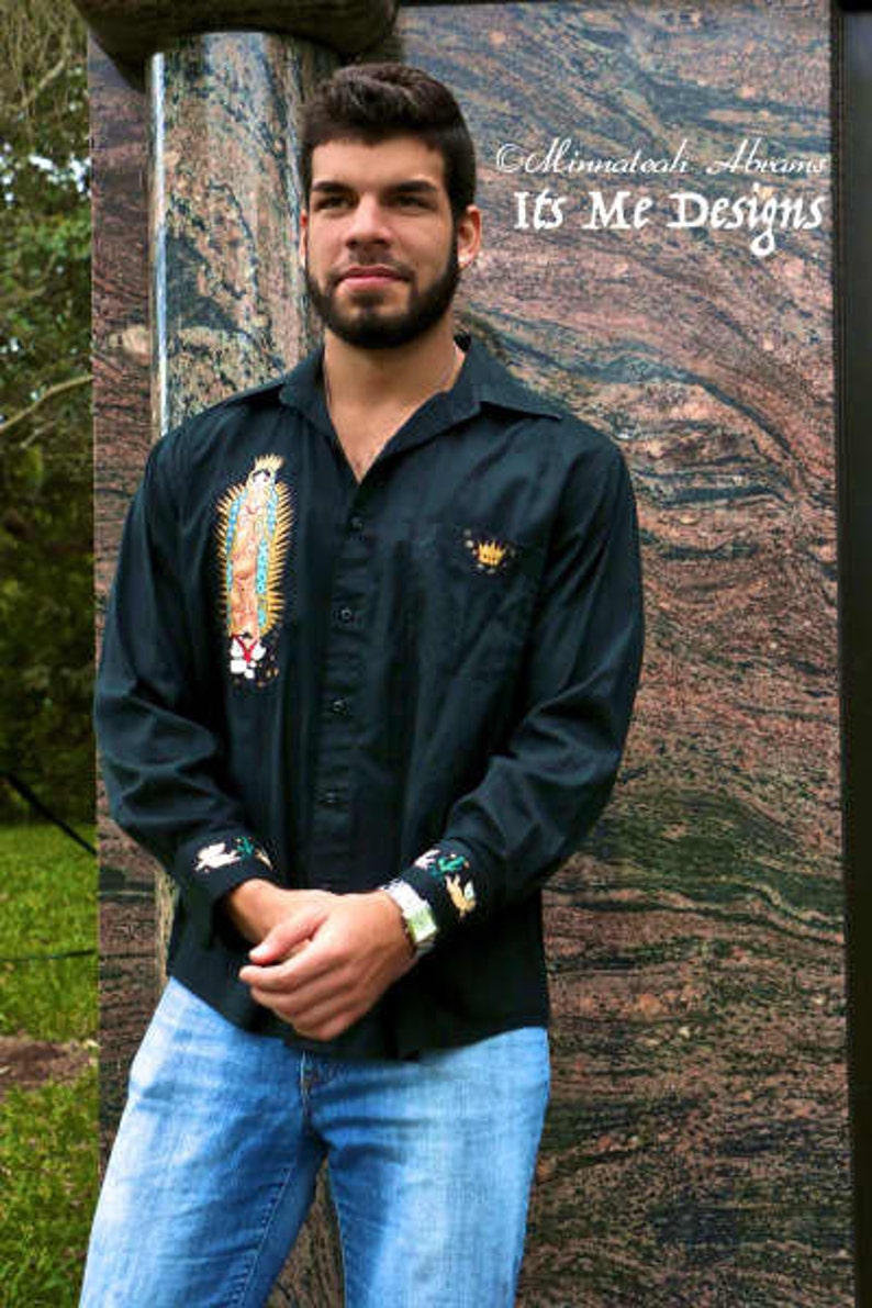 May include: A black long-sleeve button-down shirt with embroidered details. The shirt features a religious image and a crown on the left chest. The shirt is worn by a person with a beard and a casual expression.