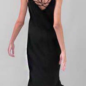 Puede incluir: Un vestido negro de sat&eacute;n con un detalle de tirantes cruzados en la espalda. El vestido tiene un corpi&ntilde;o ajustado y una falda fluida.