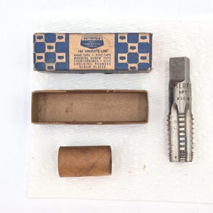 May include: A set of vintage Butterfield tools, including a tap and die set. The image shows a blue and white box with text, an open brown box, a brown tube, and a silver metal tap. The text on the box reads "THE COMPLETE LINE".