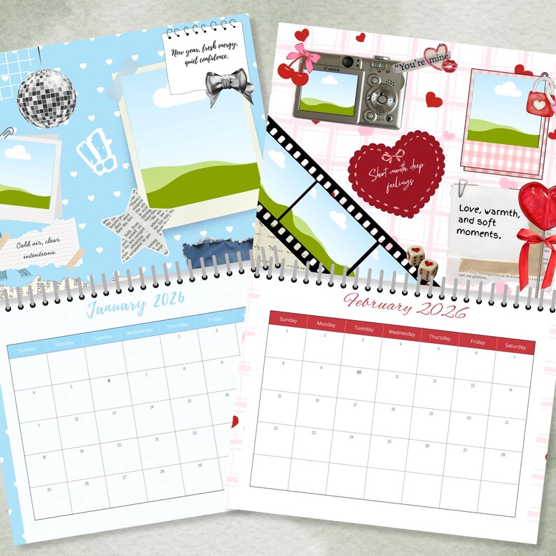 May include: Two spiral-bound calendars, one blue and one pink, open to January and February 2026. The January calendar has a light blue background with decorative elements. The February calendar has a pink background with hearts and other decorations.
