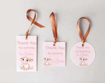 May include: Three pink gift tags with brown ribbon. Each tag has the text "Thank You for coming love, Charlotte" and a cartoon cow illustration with floral accents. One tag is rectangular, one square, and one round.