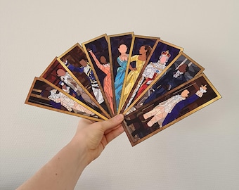 May include: A set of ten bookmarks featuring characters from the musical Hamilton. Each bookmark is a stained glass style illustration of a different character, including Alexander Hamilton, Aaron Burr, Eliza Schuyler, and King George III. The bookmarks are all framed in gold.