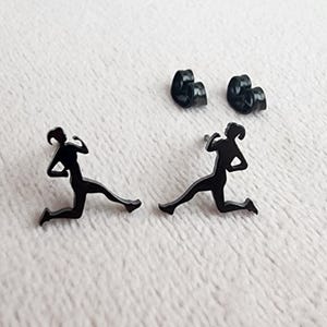 Puede incluir: Un par de pendientes de botón negros con la silueta de un corredor. Los pendientes son de metal y tienen un diseño simple y moderno.