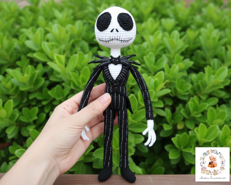 May include: Crocheted Jack Skellington doll. The doll has a white head with black eyes and a stitched mouth. It wears a black suit with white pinstripes, a bat-shaped bow tie, and white gloves. The doll is approximately 12 inches tall.