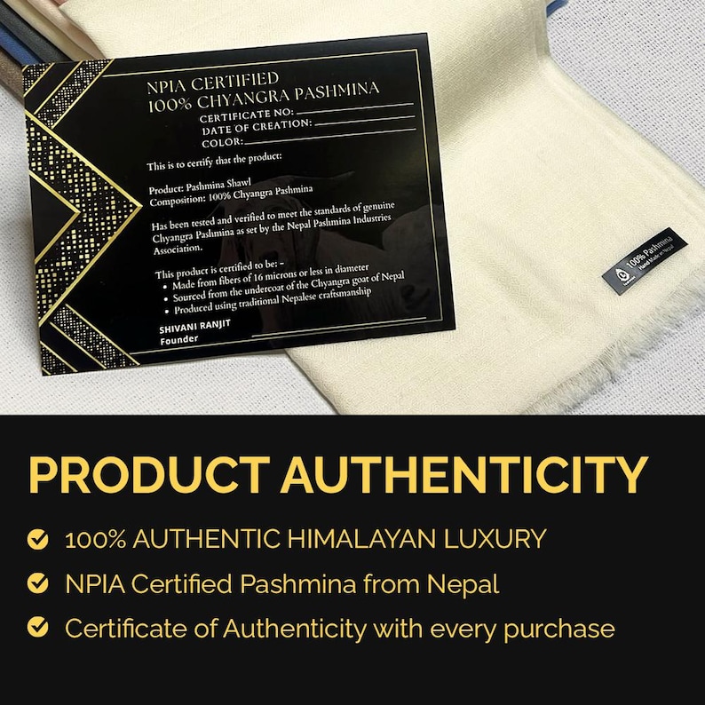 May include: A cream-colored pashmina shawl with a small black label reading 100% Pashmina, accompanied by a black NPIA certification card with gold geometric accents. The card text details 100% Chyangra Pashmina, 16 microns or less, and Nepal origin.