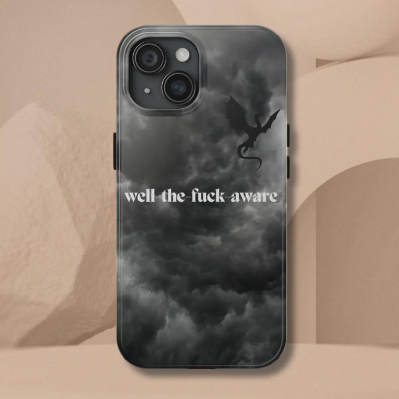 K&ouml;nnte beinhalten: Transparente Handyh&uuml;lle mit einem Design eines dunklen, bew&ouml;lkten Himmels und einer Drachensilhouette. Der Text "well the fuck aware" ist in Wei&szlig; gedruckt. Die H&uuml;lle hat einen schwarzen Rand und bedeckt R&uuml;ckseite und Seiten des Telefons.