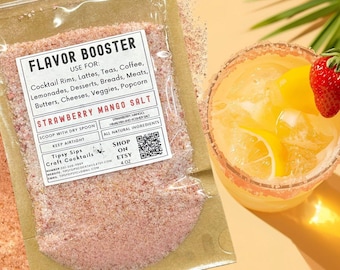 May include: A clear bag of Strawberry Mango Salt with text "Flavor Booster" and "Tipsy Sips Craft Cocktails". A cocktail with a strawberry garnish sits next to the bag. The salt is for cocktail rims, lattes, teas, and more.