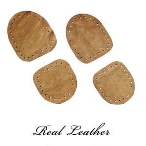 Può includere: Quattro suole di pantofole in pelle marrone con fori preforati per cucire sono esposte su sfondo bianco. Il testo "Real Leather Slipper Soles" è scritto in elegante corsivo sotto.