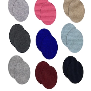 Può includere: Nove paia di toppe termoadesive in vari colori, tra cui grigio, rosa, beige, grigio scuro, blu, azzurro, grigio chiaro, bordeaux e blu navy. Le toppe sono ovali e realizzate in 100% cashmere. Il testo in basso recita "Iron-on Pair Patches 100% Cashmere."