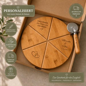 Könnte beinhalten: Ein rundes Pizza-Schneidebrett aus Holz mit sechs vorgeschnittenen Stücken, graviert mit dem Text 'ZWEI HERZEN. Ein Versprechen, FÜR IMMER.', zwei Herzen sowie den Namen 'Mareike & Nils' und dem Datum '11.07.2026'. Inklusive Pizzaschneider aus Metall.