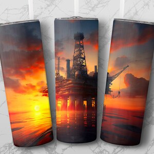 May include: Three stainless steel insulated tumblers with a sunset oil rig design. The image features a vibrant sunset with orange, yellow, and red hues, reflecting on the water. The oil rig is a prominent silhouette.