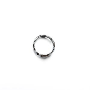 May include: A silver-colored ring with an irregular, textured surface. The ring is circular and appears to be made of metal. The design is minimalist and modern, suitable for everyday wear. The ring is shown against a white background.