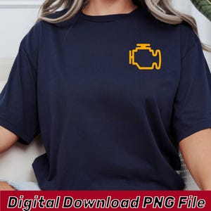 Puede incluir: Una camiseta azul marino de manga corta con un gráfico amarillo del símbolo de luz de motor en la parte superior izquierda del pecho. La camiseta tiene cuello redondo y corte estándar. El texto Digital Download PNG File está abajo.