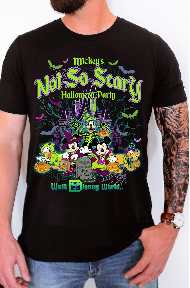 May include: Black t-shirt featuring a Halloween design with Mickey Mouse and friends. The graphic includes the text "Mickey's Not-So-Scary Halloween Party" in green and purple, along with bats and a spooky castle. The Walt Disney World logo is also present.