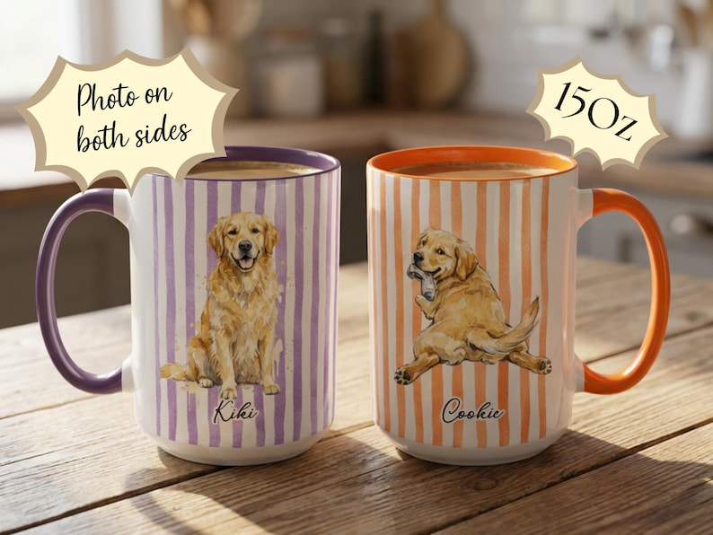 May include: Two 15 oz. ceramic mugs with dog illustrations. One mug has a purple handle and rim with a sitting golden retriever on a striped background. The other mug has an orange handle and rim with a dog holding a bone.