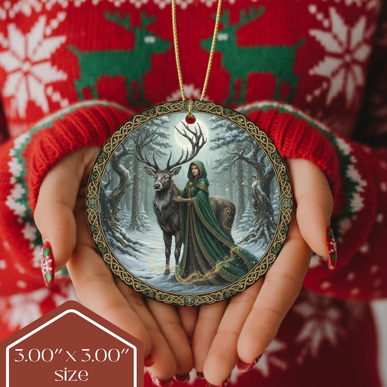 May include: Round Christmas ornament featuring a winter scene with a woman in a green cloak and a deer. The ornament is 3.00" x 3.00" and has a gold-colored hanging string. The border has a Celtic knot design.
