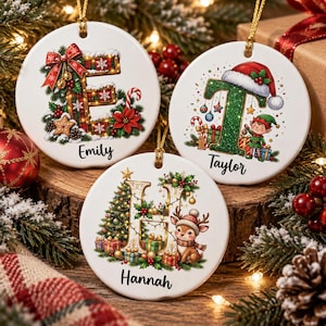 May include: Three round white ceramic ornaments with gold hanging strings. One features a plaid letter E with a red bow, one a green letter T with a Santa hat and elf, and one a gold letter H with a Christmas tree, gifts, and a reindeer.
