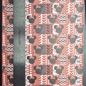May include: A sheet of patterned faux leather featuring a repeating grid of black mouse silhouettes, white polka dots, and red chevron stripes. A Westcott stainless steel ruler is placed vertically on the left, measuring 12 inches in length.