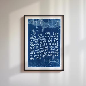 Op de afbeelding: Ingelijste kunstafdruk in blauw en wit. De print heeft een donkerblauwe achtergrond met witte tekst en illustraties. De tekst is in een gestileerd lettertype. De zwarte lijst contrasteert met de witte muur waaraan hij hangt.