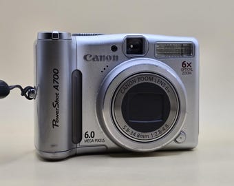 Fotocamera digitale compatta Canon Powershot A700 da 6.0 MP, colore argento, con scheda SD e custodia.