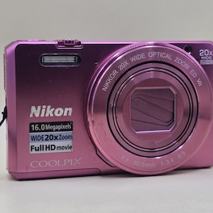 Câmera digital Nikon COOLPIX S7000 rosa de 16 MP com zoom de 20x, Wi-Fi e resolução Full HD (ano 2000).