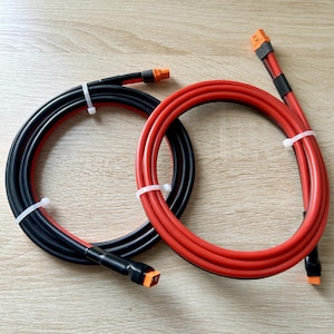 May include: Two rolls of electrical wire with orange connectors. One roll is black and the other is red.