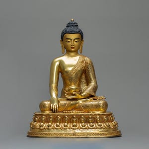 Peut inclure: Une statue dorée de Bouddha en position assise, avec une expression sereine. La statue présente des détails complexes sur les robes et la base, avec une coiffure bleu foncé. La figure tient un petit bol. La statue est une représentation de l'art bouddhiste.