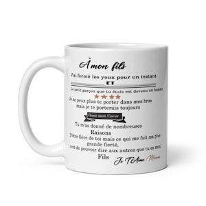 Peut inclure: Mug en céramique blanche avec une anse incurvée. Le mug présente du texte français en écriture noire, dont "À mon fils" et un message sincère. Le design comprend des étoiles et les mots "Dans mon Coeur".