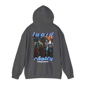 May include: A dark gray hooded sweatshirt with a graphic print of a man in a dark suit and tie. The graphic text reads "lucid reality" with the words "everything is real..." underneath.