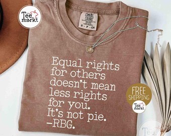 May include: A brown t-shirt with the quote "Equal rights for others doesn't mean less rights for you. It's not pie. -RBG." printed in white. The shirt has a crew neck and short sleeves. A silver necklace with a pendant is on the shirt.