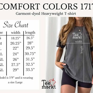 May include: A dark gray Comfort Colors 1717 garment-dyed heavyweight t-shirt. The image includes a size chart with measurements in inches for sizes S to 4XL. The model is wearing a size Large. The Tee Markt logo is visible.
