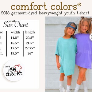 May include: Two young people wearing oversized t-shirts, one light blue and one purple. The image includes a size chart with measurements in inches for youth t-shirts. The brand name "comfort colors" is visible.