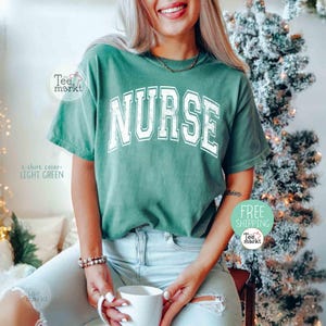 May include: Light green t-shirt with the word "NURSE" in white block letters. The shirt is light green and has a slightly faded look. The text "t-shirt color: LIGHT GREEN" is visible on the left side of the shirt.