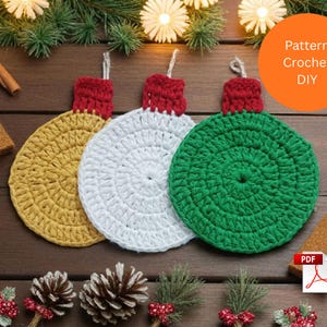 May include: Three handmade crochet Christmas ornament designs in yellow, white, and green, each with a red top and a loop for hanging. The ornaments are displayed on a wooden surface with festive decorations, including pine needles and cinnamon sticks. The image includes the text "Pattern Crochet DIY".