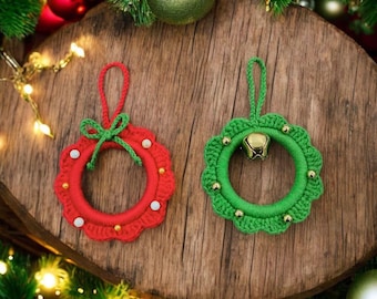 May include: Two handmade Christmas wreath ornaments. One is red with white and gold accents and a green bow. The other is green with gold accents and a small gold bell. Both are crocheted and have a loop for hanging.