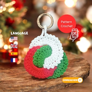 May include: A handmade crochet keychain in red, white, and green, with a gold-colored ring. The keychain is in a circular design. The image includes the text "Pattern Crochet" and "Download Now".