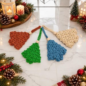 May include: Four crocheted ornaments in rust, green, blue, and cream, each featuring a star-like pattern, a wooden bead, and a hanging loop. These decorative items are arranged in a fan shape on a white surface, showcasing intricate yarn textures.